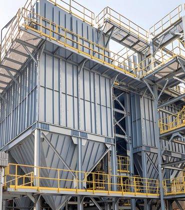 A large industrial facility features a metal-structured dust collector, showcasing advanced industrial design and functionality.