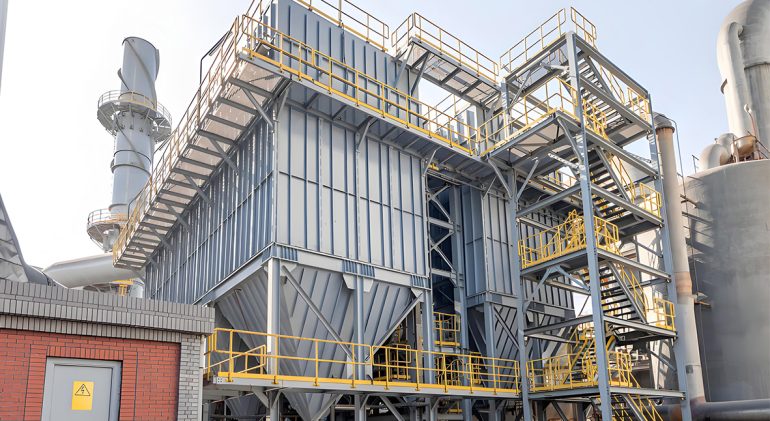 A large industrial facility features a metal-structured dust collector, showcasing advanced industrial design and functionality.